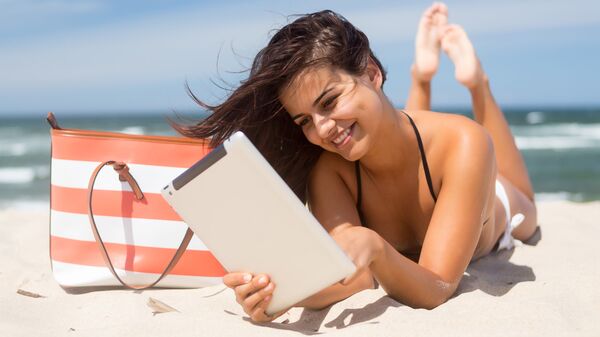 Девушка с планшетом на пляже