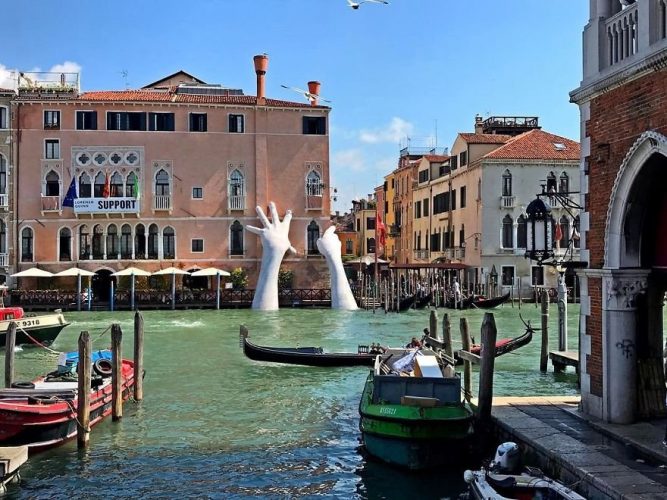 Художник Лоренцо Куинн установил восьмиметровые руки у отеля Ca`Sagredo. Они поднимаются из воды и опираются на стену здания. Скульптура называется “Поддержка”. Венеция